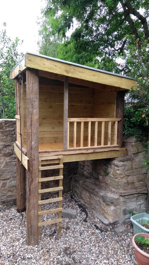 Custom made tree house with a ladder and climbing rope
