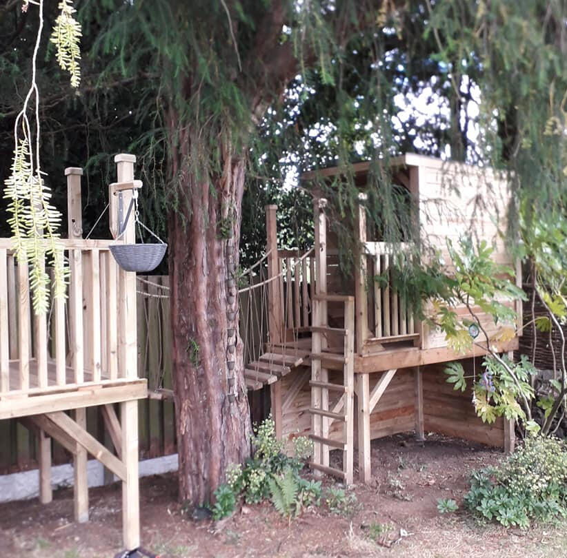 The treehouse is in two parts with a rope brigde connecting them