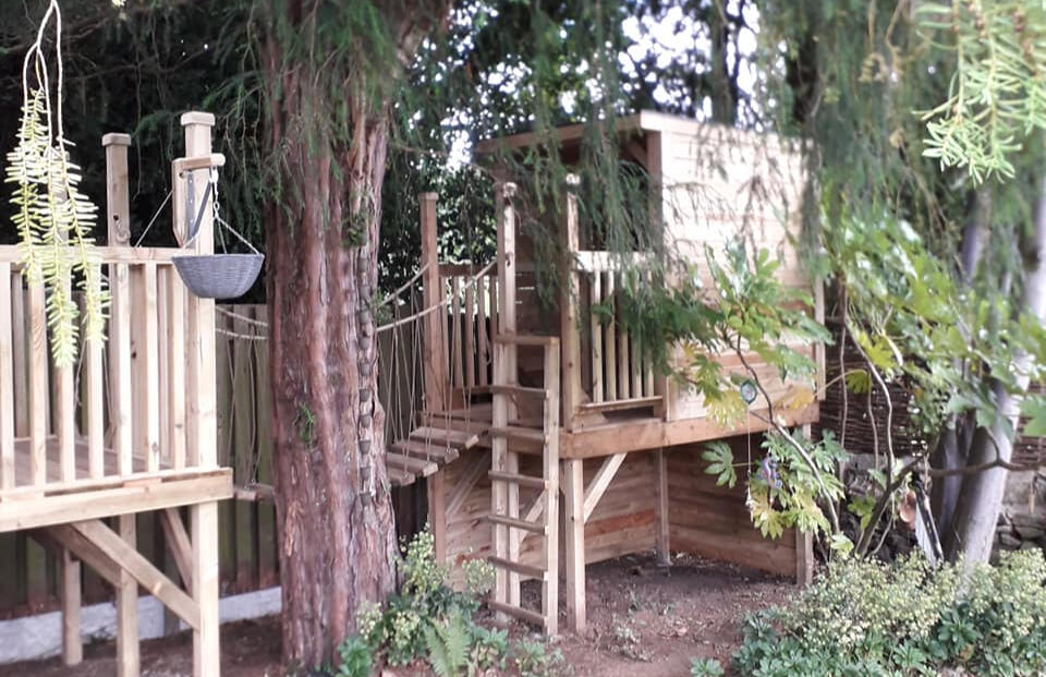 A multi-level treehouse for a lovely corner of the garden. Complete with rope bridge, climbing wall, pulley system and tubular slide.